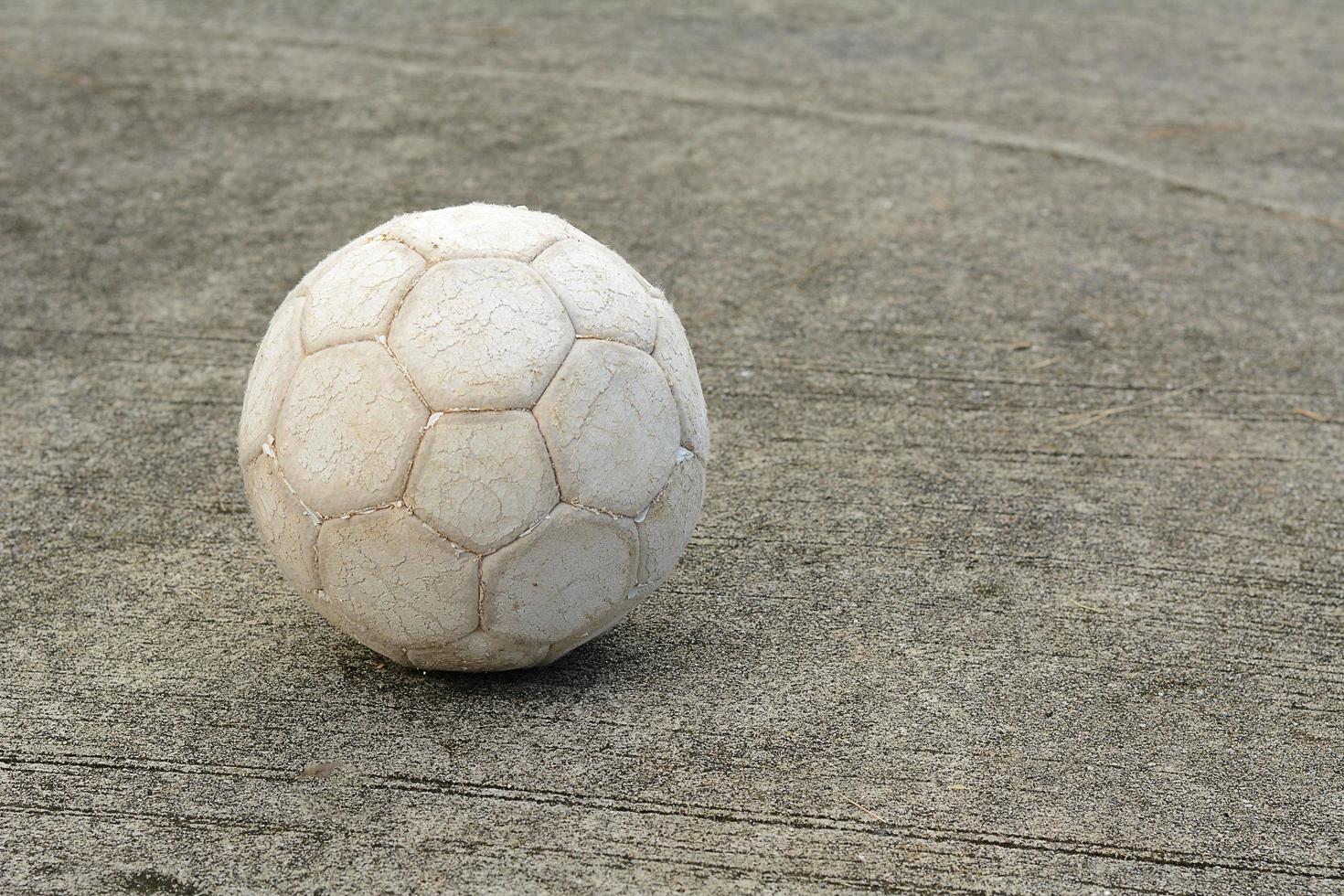 Alter Fußball auf Zementboden foto