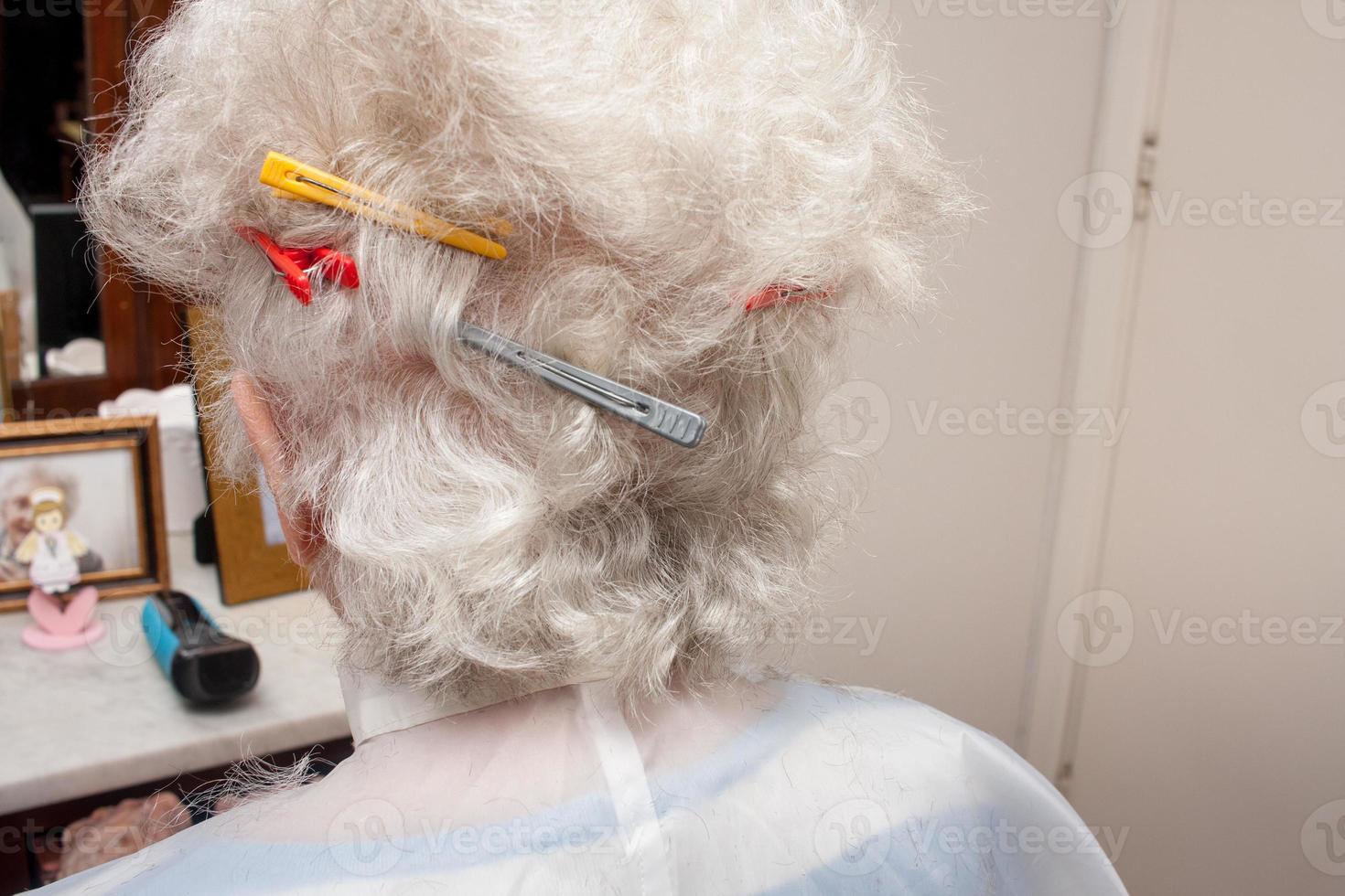 ältere Dame, die bequem von zu Hause aus einen Haarschnitt bekommt foto