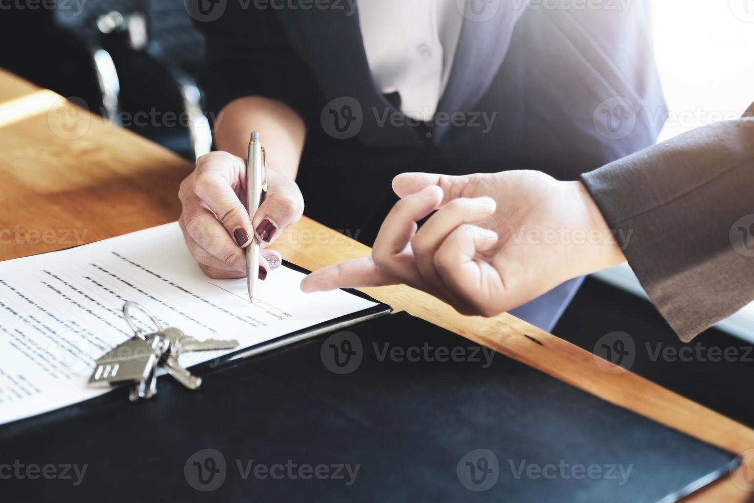 Der Immobilienmakler gibt dem Kunden eine Vereinbarung mit Stift und Dokumenten, um den Vertrag zu unterzeichnen. Konzept Vereinbarung. foto