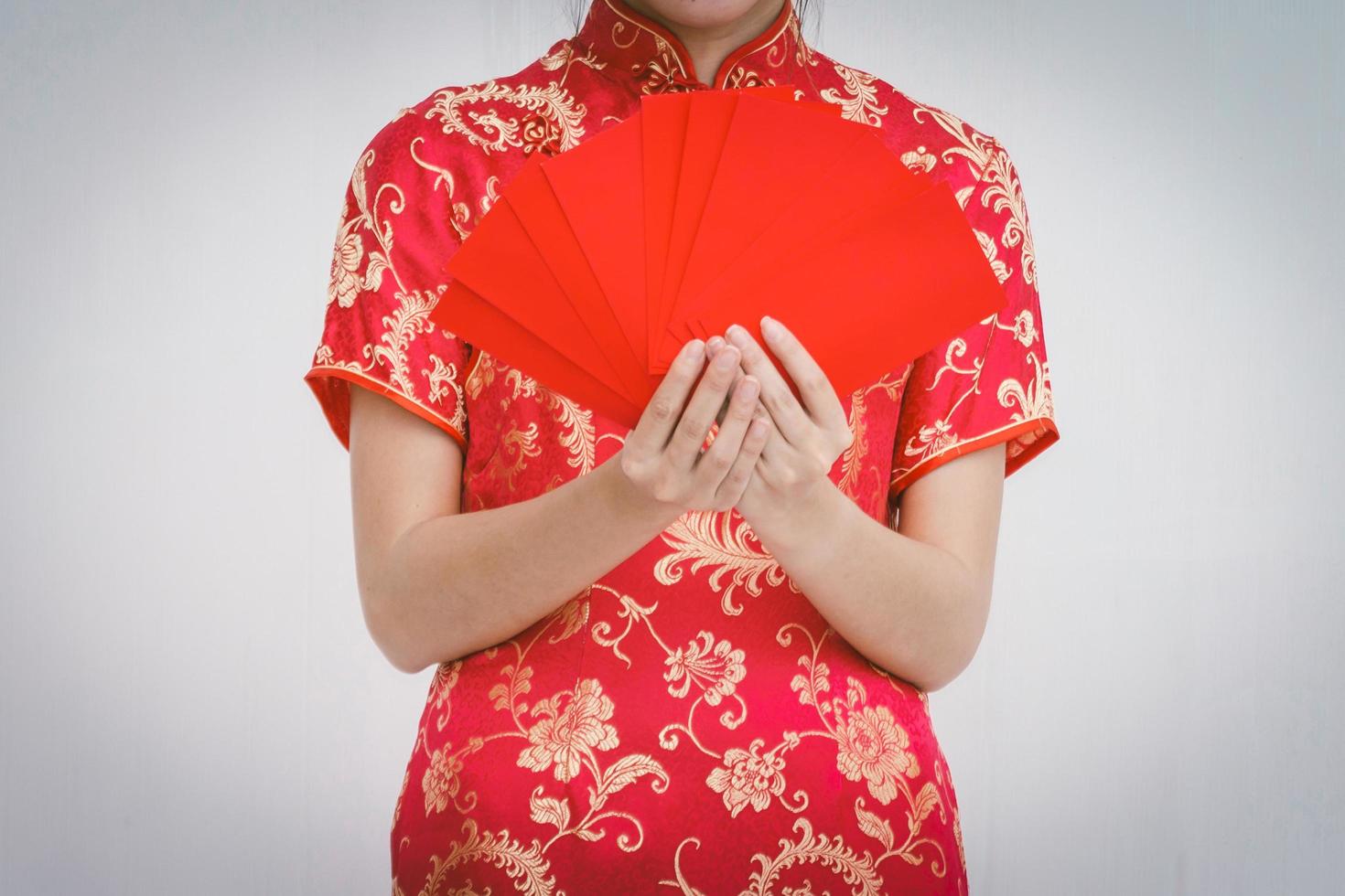 asiatische frau, die roten umschlag hält, frauenabnutzung cheongsam, chinesisches neujahr foto