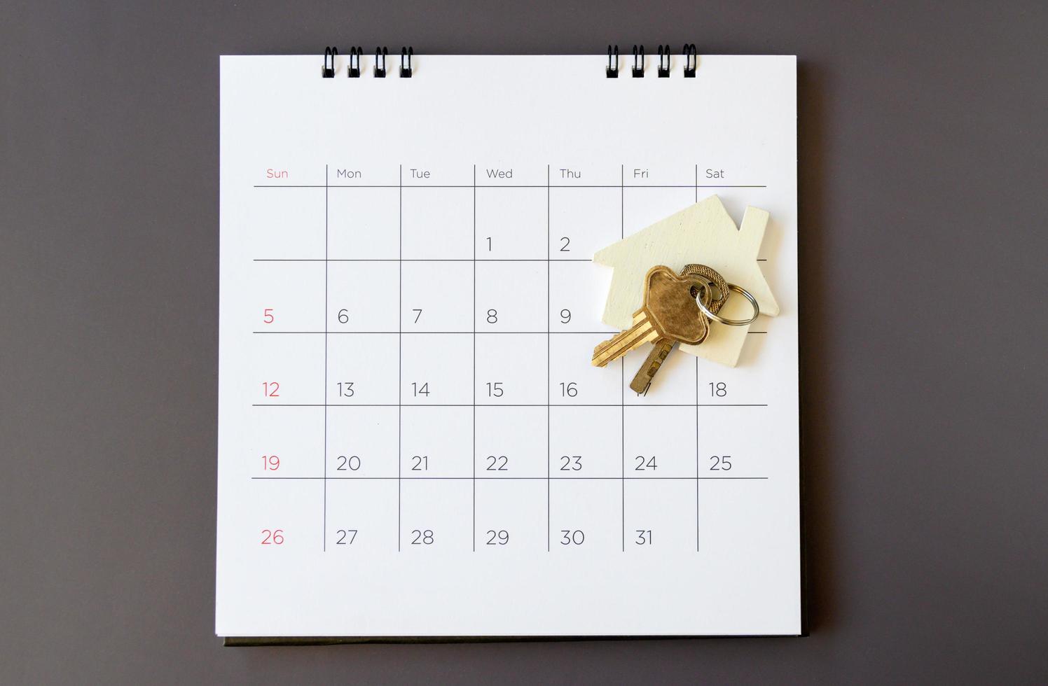 Kalender und Haus auf dem Tisch. Tag des Kaufs oder Verkaufs eines Hauses oder Zahlung für Miete oder Darlehen. foto