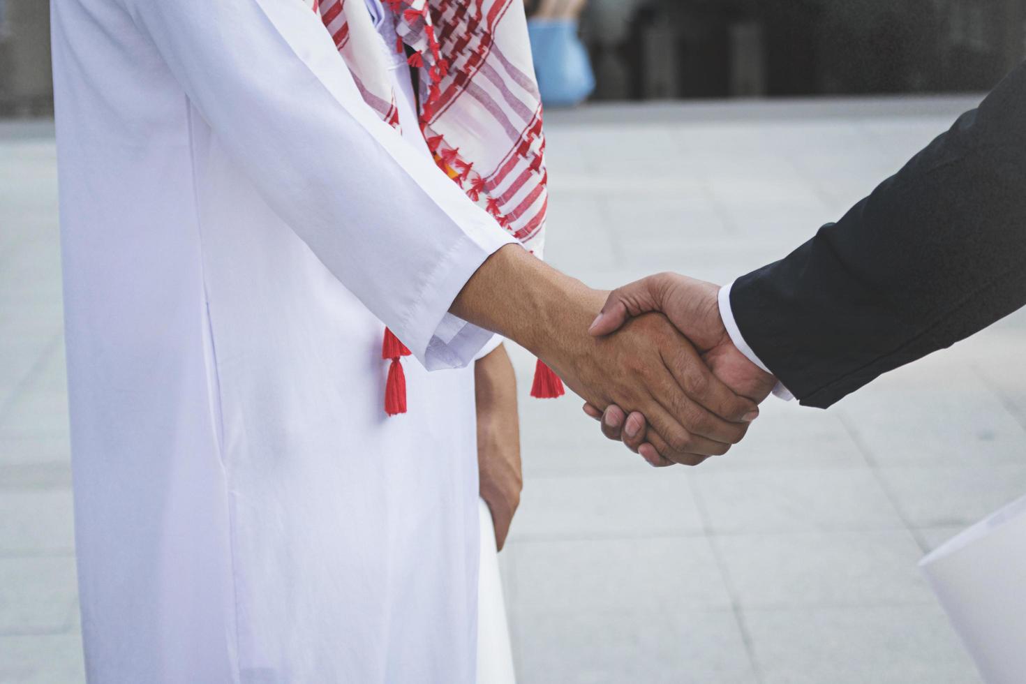 Arabische Geschäftsleute beim Händeschütteln auf der Baustelle foto