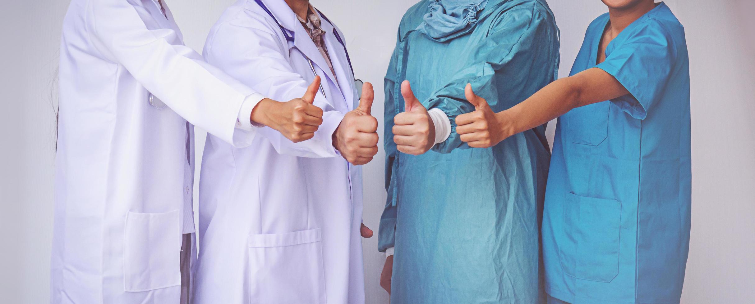 ärzte und krankenschwestern koordinieren hände. ärzte daumen hoch, konzept teamwork foto