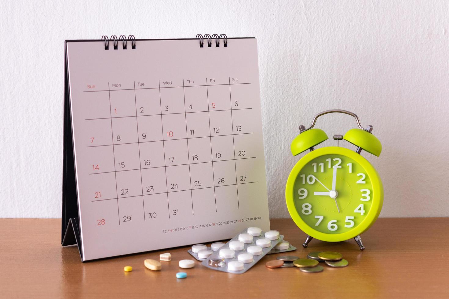 Kalender und Medikamente auf dem Tisch. foto