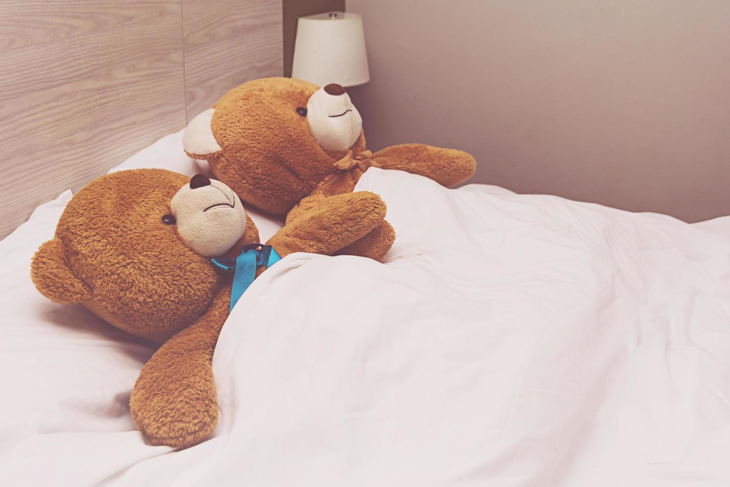 Teddybär liegt im Bett foto