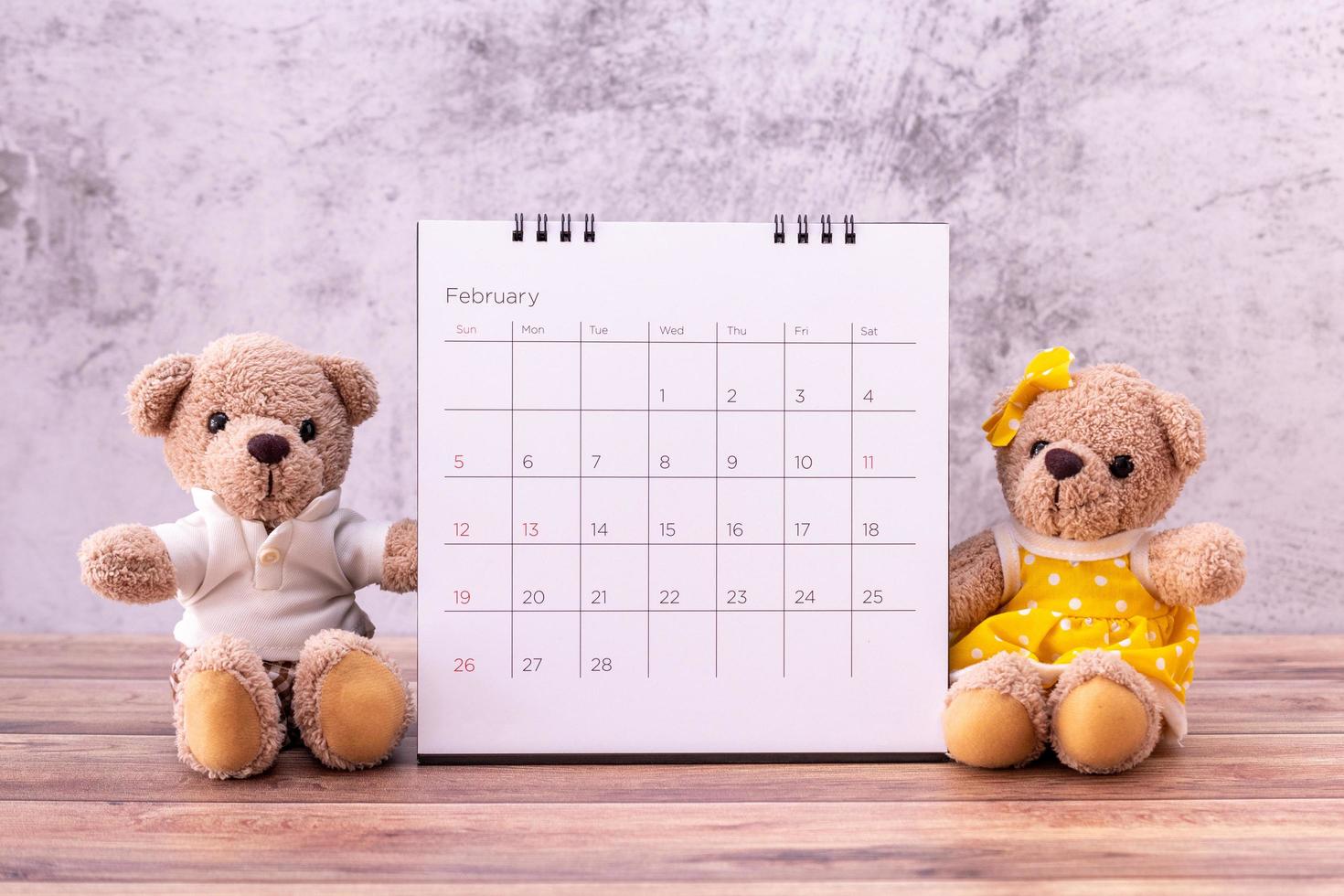 Paar Teddybär mit Kalender auf Tisch aus Holz. valentinstag feier foto