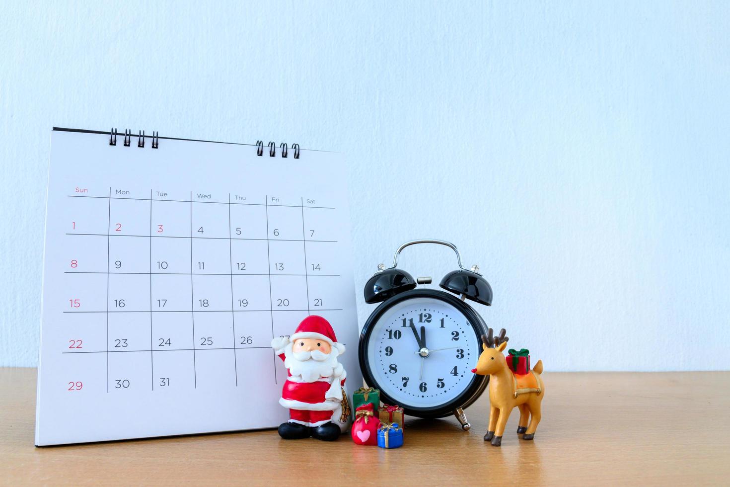 Kalender und Weihnachtsmann auf dem Tisch. frohes neues jahr und weihnachtskonzept foto