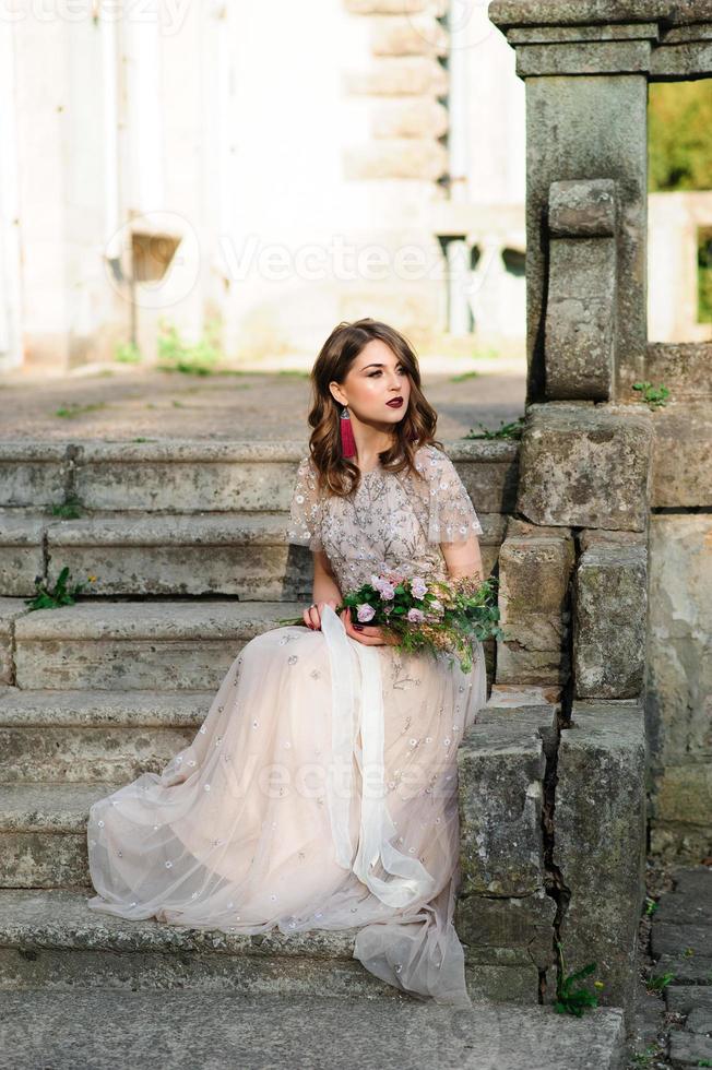 sehr schönes mädchen die braut unter einem schleier, beige hochzeitskleid foto