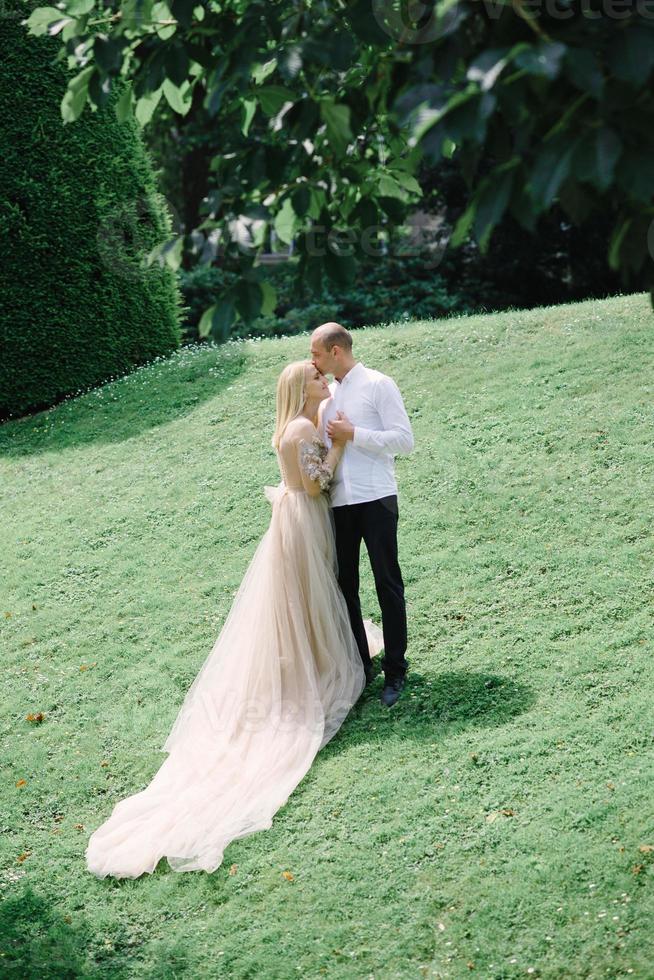 ein trendiges junges paar geht im sommer in der stadt spazieren, die junge frau trägt ein luxuskleid foto