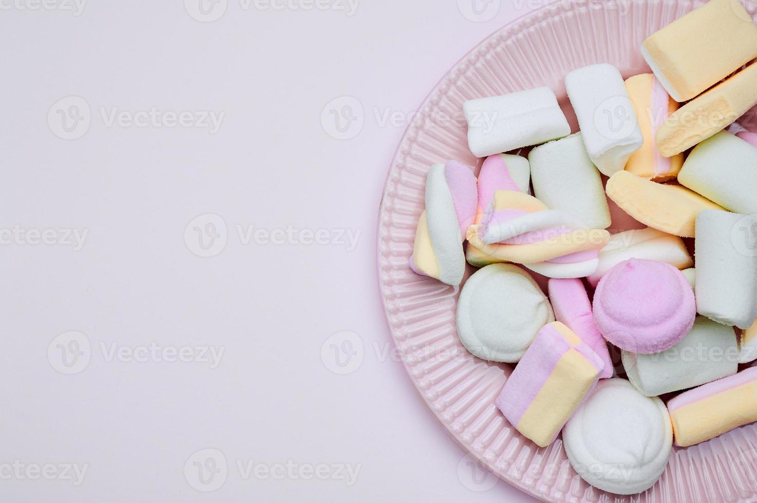 rosa Teller mit Marshmallows in Pastellfarben ausgeschnitten foto