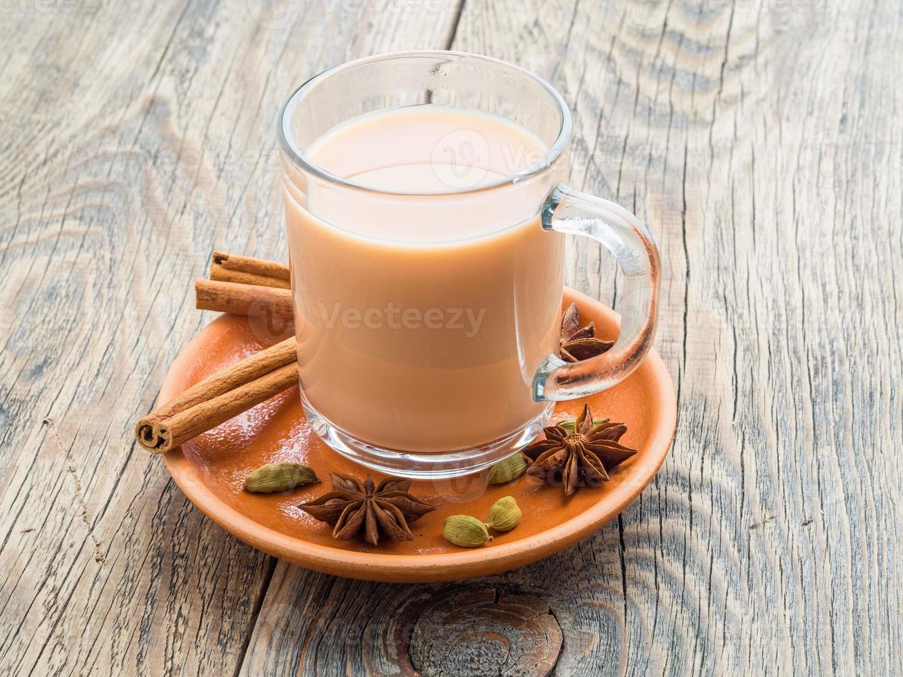 masala indisches getränk beim fest von holi. Tee mit Milch und Gewürzen in einem Glasbecher. foto