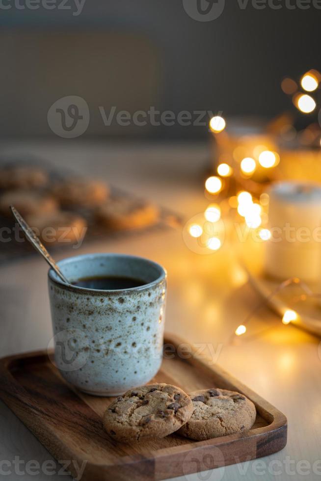 gemütlicher abend, becher getränk, festliche dekorationen, kerzen und lichtergirlanden. foto