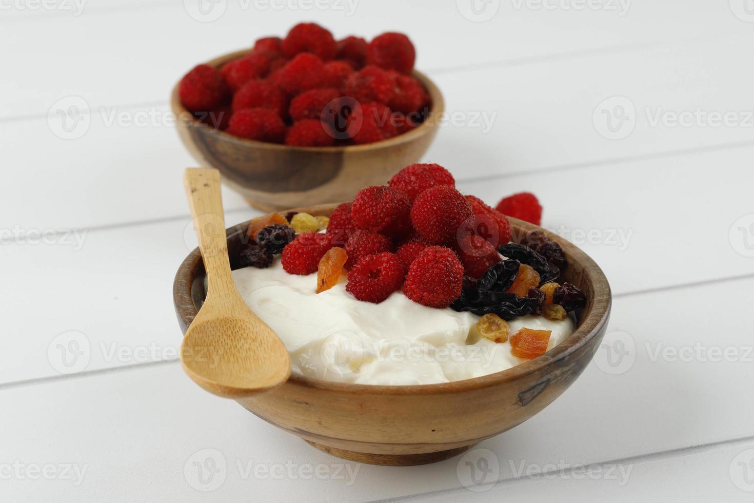 hausgemachter griechischer Joghurt mit Himbeeren und Trockenfrüchten foto