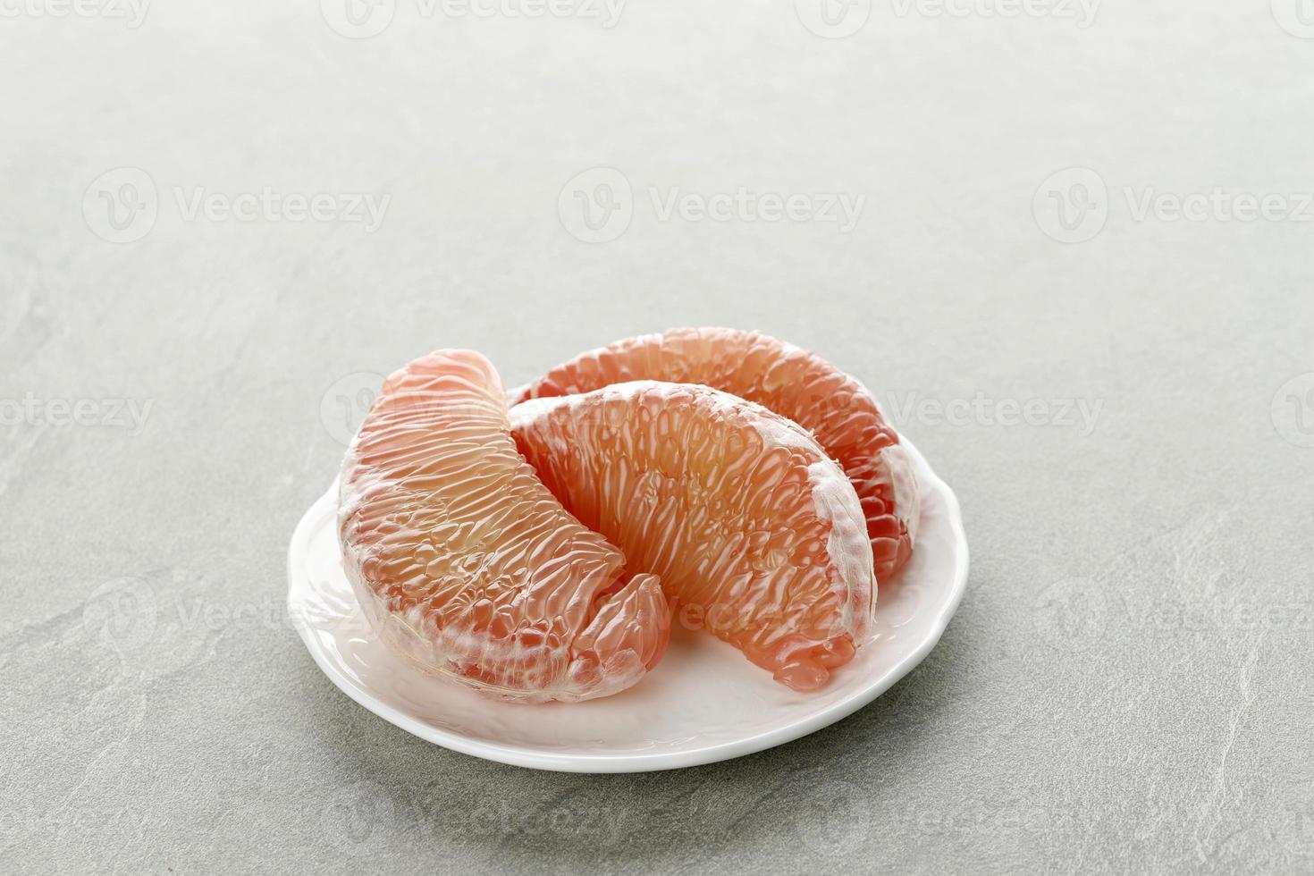 Pomelo-Frucht auf dem Teller. Grapefruit, Jeruk Bali oder Bali Pampelmuse. große orangen in indonesien sind als bali-orangen oder jeruk bali bekannt. foto