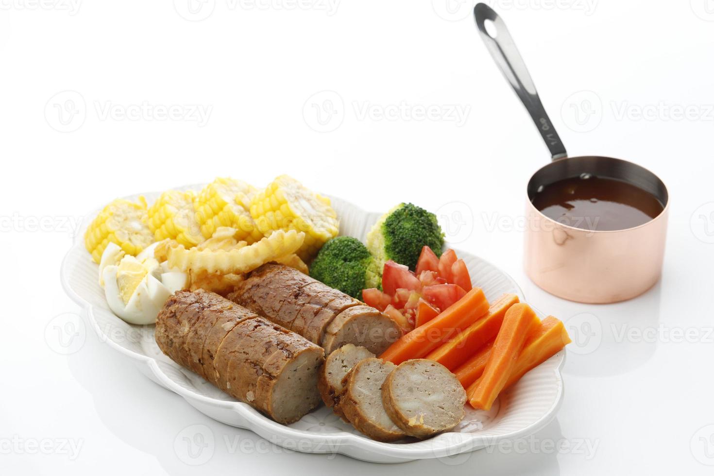 Hühnergalantine, in Scheiben geschnitten, serviert auf weißem Teller mit BBQ-Sauce und Gemüse. selektiver Fokus foto