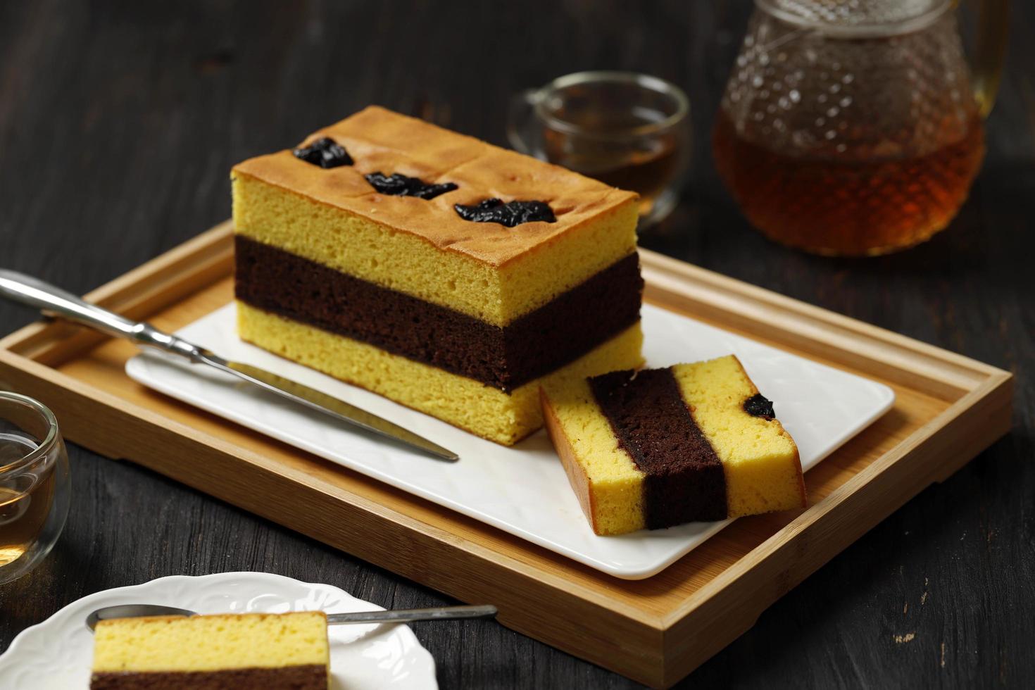 Spiku oder Lapis Surabaya, indonesischer Dreischichtkuchen mit Erdbeermarmelade zwischen den Schichten. mit Pflaumen belegt. foto