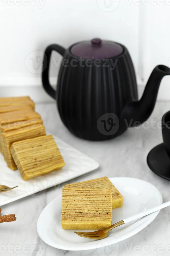 Slice Lapis Legit auf Teller, indonesischer Schichtkuchen oder Lapis Legit auf Keramikplatte, weißes Konzept für hausgemachte Backwaren foto