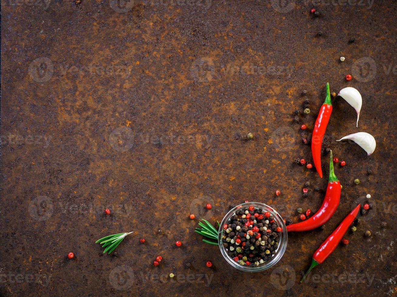 rote Chilischoten und Erbsen, Knoblauchzehe auf dunklem rostigem Metallhintergrund, Draufsicht, Kopierraum foto