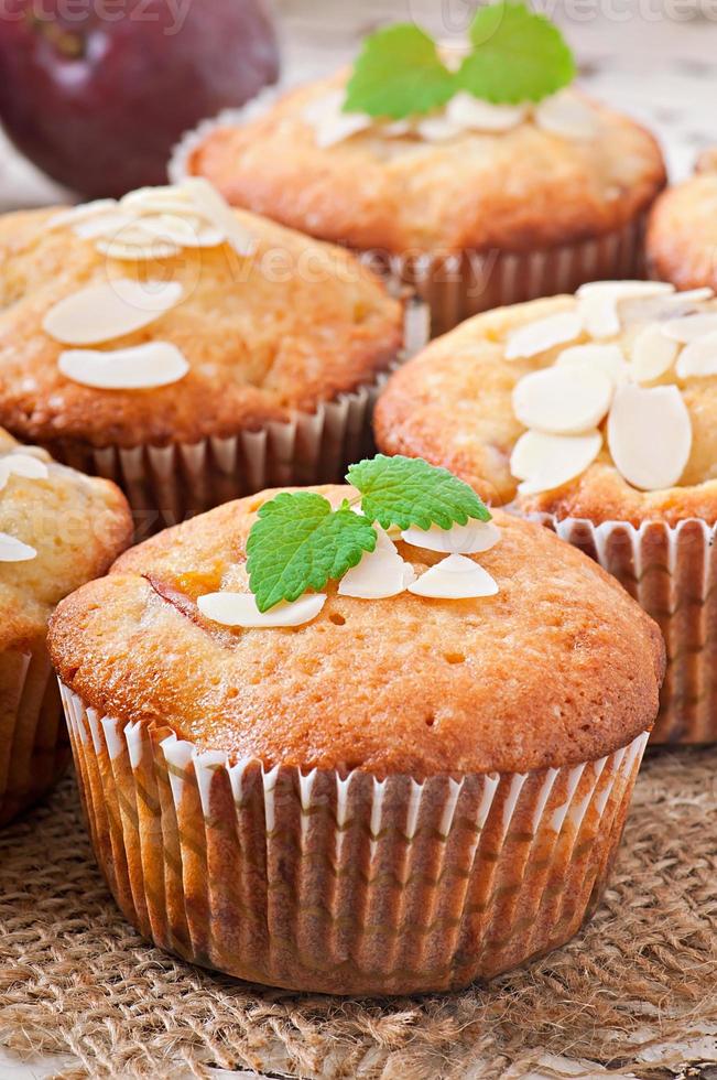 Muffins mit Pflaumen und Mandelblättern, verziert mit Minzblättern foto