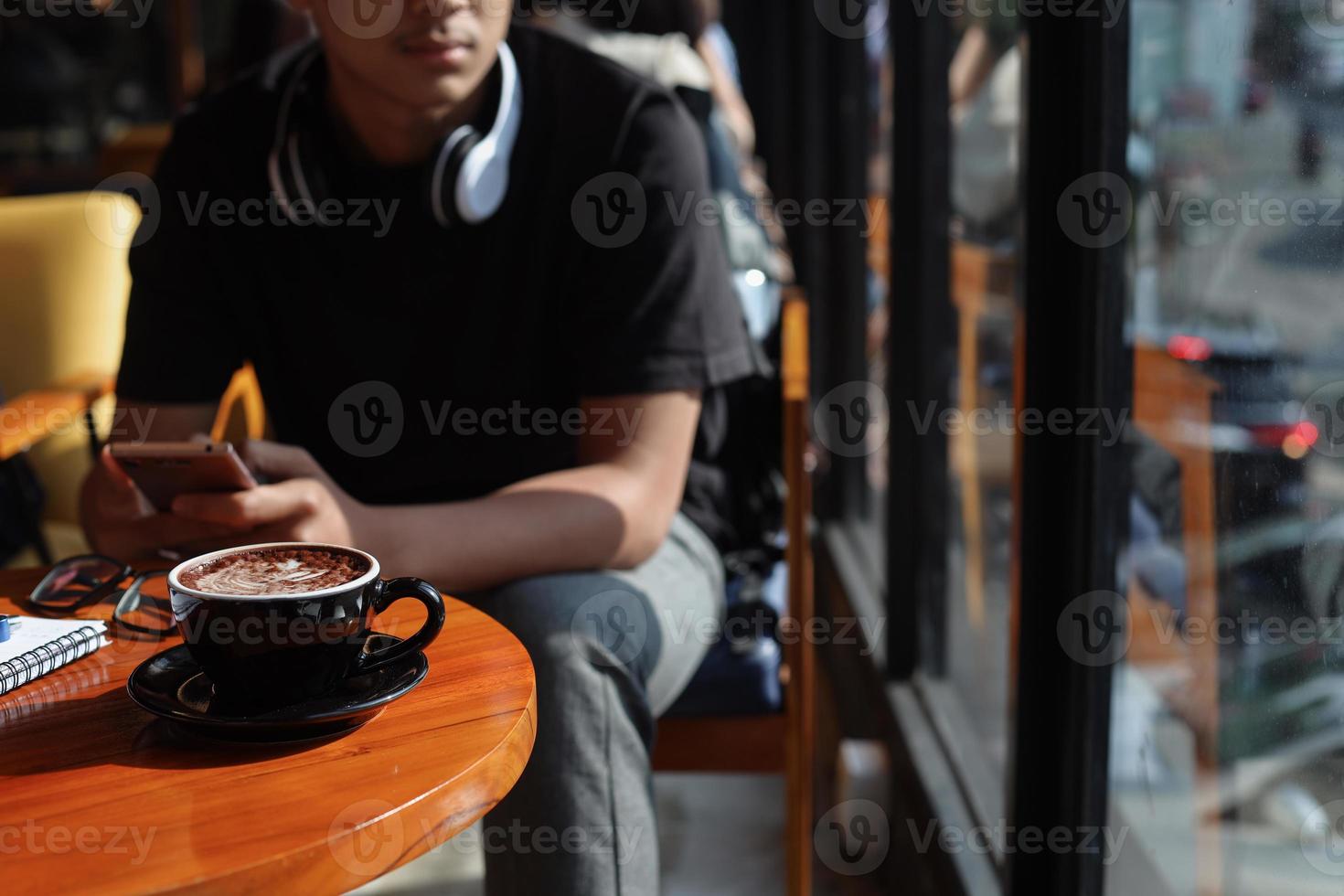 Der tausendjährige junge Mann langweilt sich, wenn er im Café auf seinen Freund wartet foto