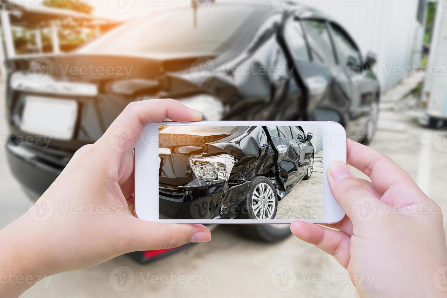 frau hält mobiles smartphone, das autounfall fotografiert foto