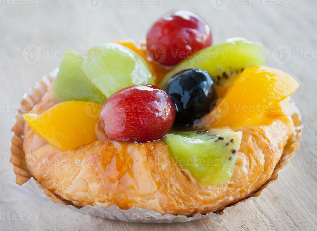 Plundergebäck mit Früchten auf Holztisch hautnah foto