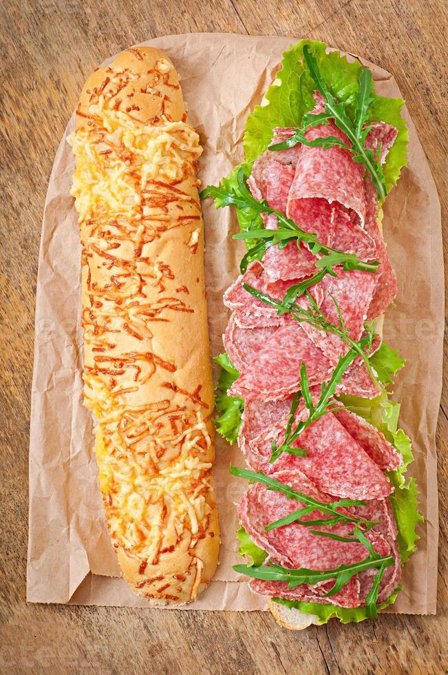 Sandwich mit Salami, Salat, Tomate und Rucola foto