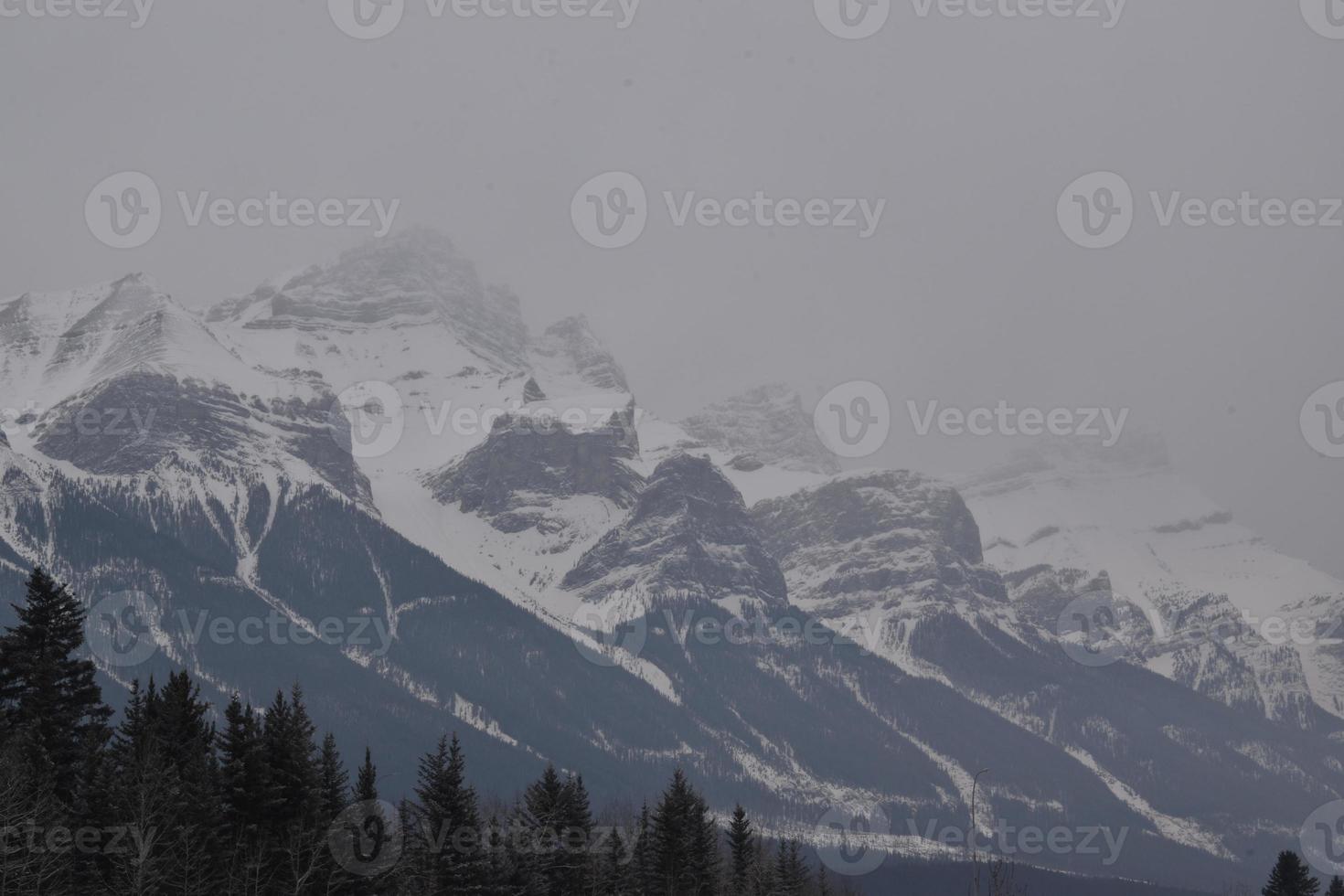 schneebedeckte felsige berge mit dunstigem grauem himmel foto