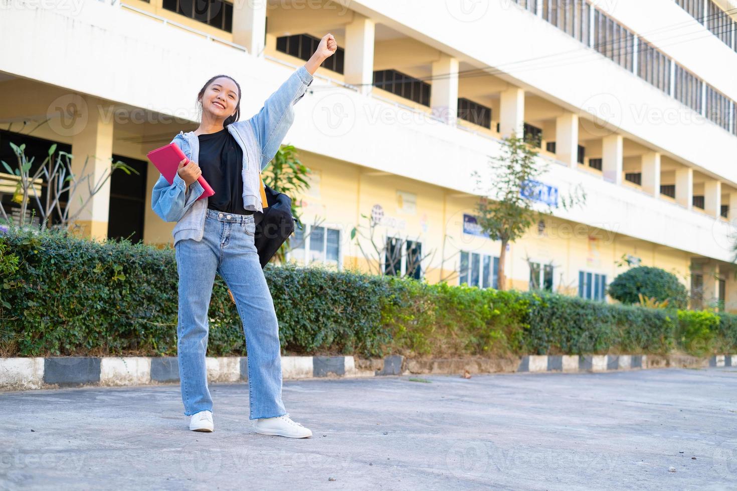 Studentin steht in der Schule mit Gebäude, asiatisches Mädchen. foto