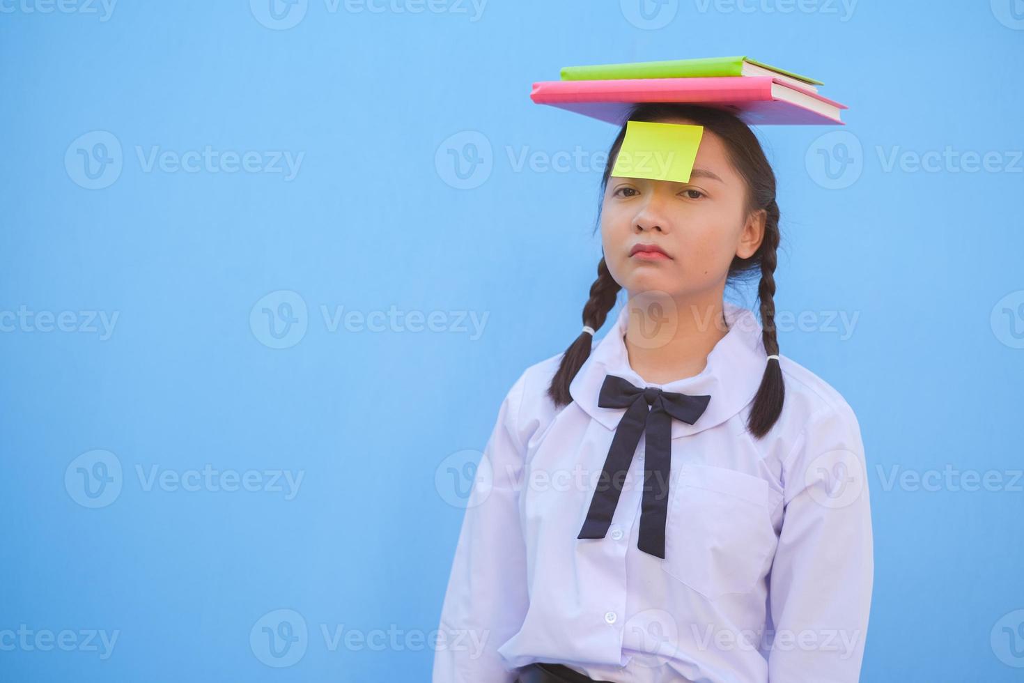 Student mit Buch und kleinem Briefpapier auf blauem Hintergrund. foto