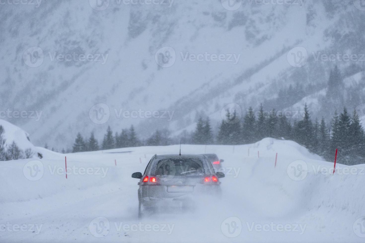 hinteres Autofahren Vorsicht durch einen Schneesturm im Tal foto