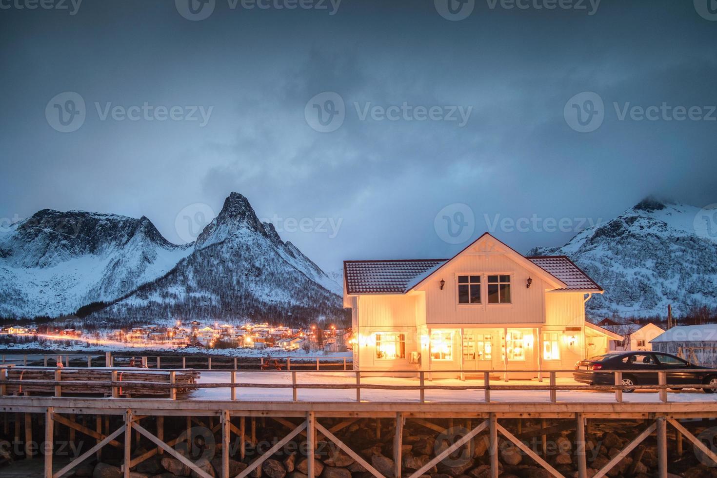 skandinavisches haus beleuchtet auf norwegischem dorf, das mit spitzenberg glüht foto