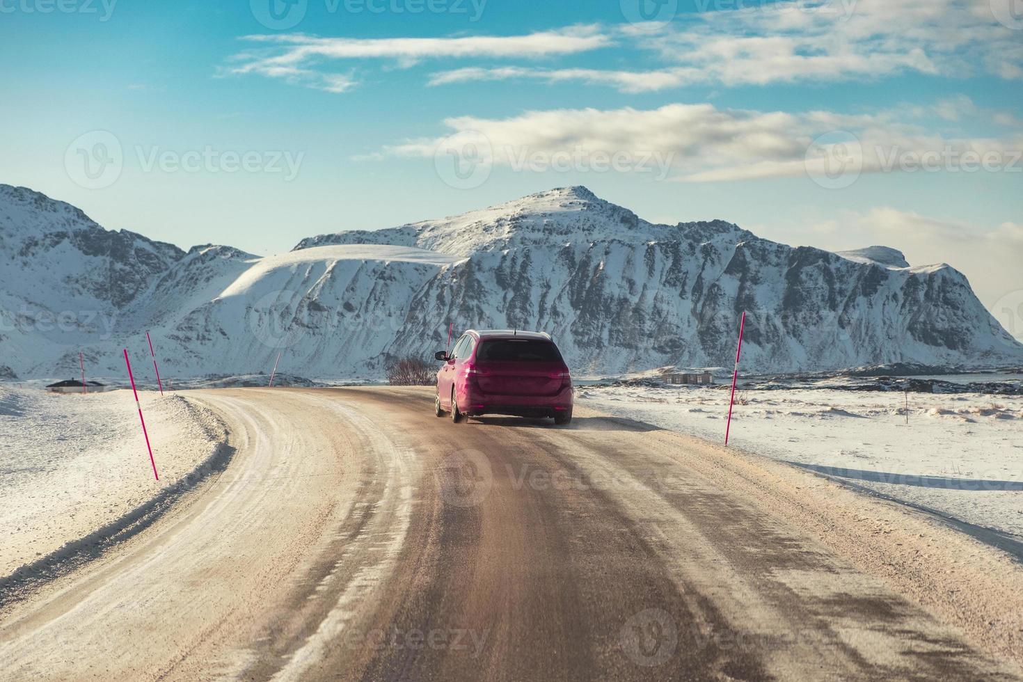 rotes suv-auto, das im winter auf der landstraße mit berg fährt foto