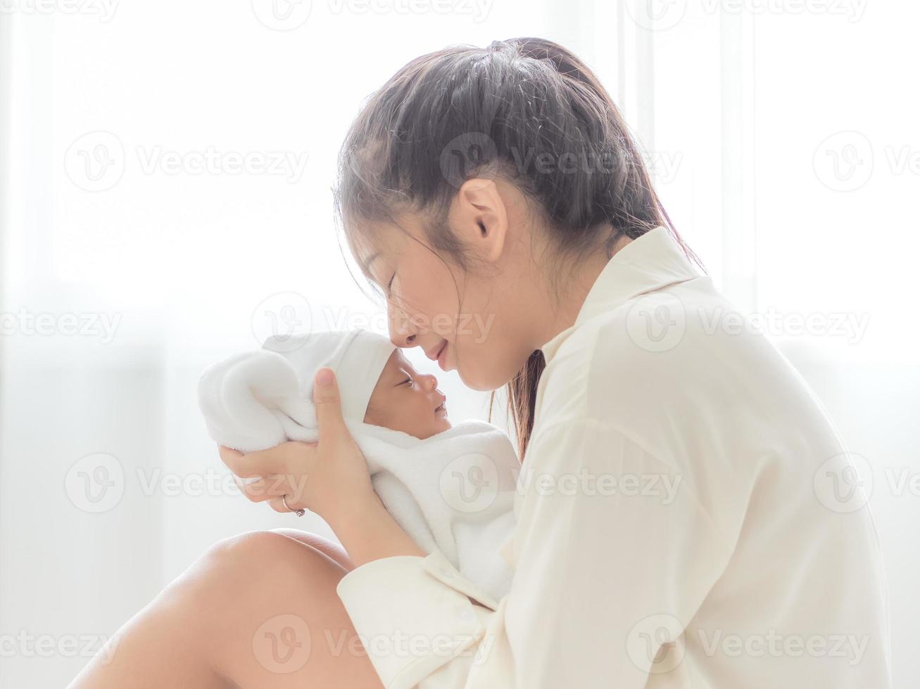 eine schöne asiatin trug ihr neugeborenes baby und küsste vor glück foto