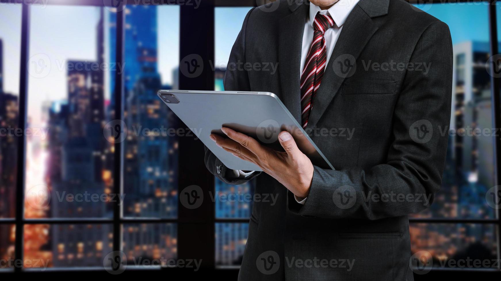 hände tippen auf einem laptop und halten smartphone im büro foto