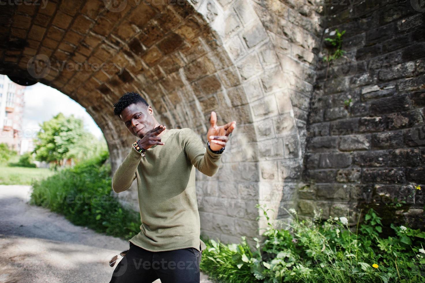 hübscher junger afroamerikaner in lässiger kleidung, der im tunnel posiert und geht. foto