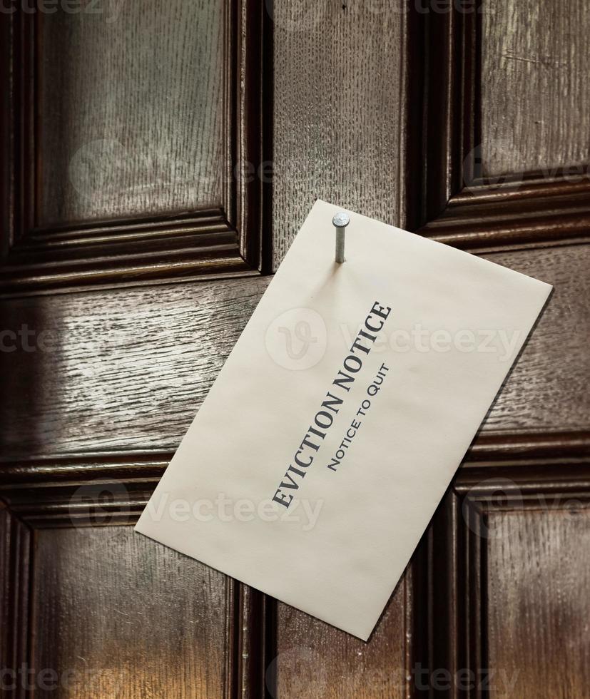 Umschlag mit Räumungsbescheid an Holztür genagelt foto