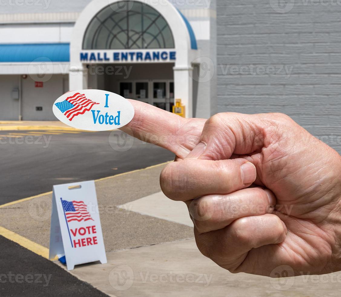Hand mit Aufkleber am Eingang zu einem Wahllokal für Wahlen im alten Einkaufszentrum foto