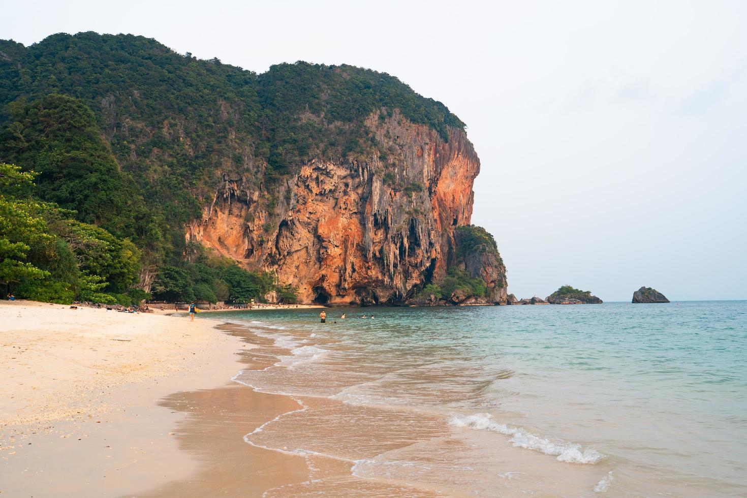 meer, strand und felsige berge am tropischen abend foto