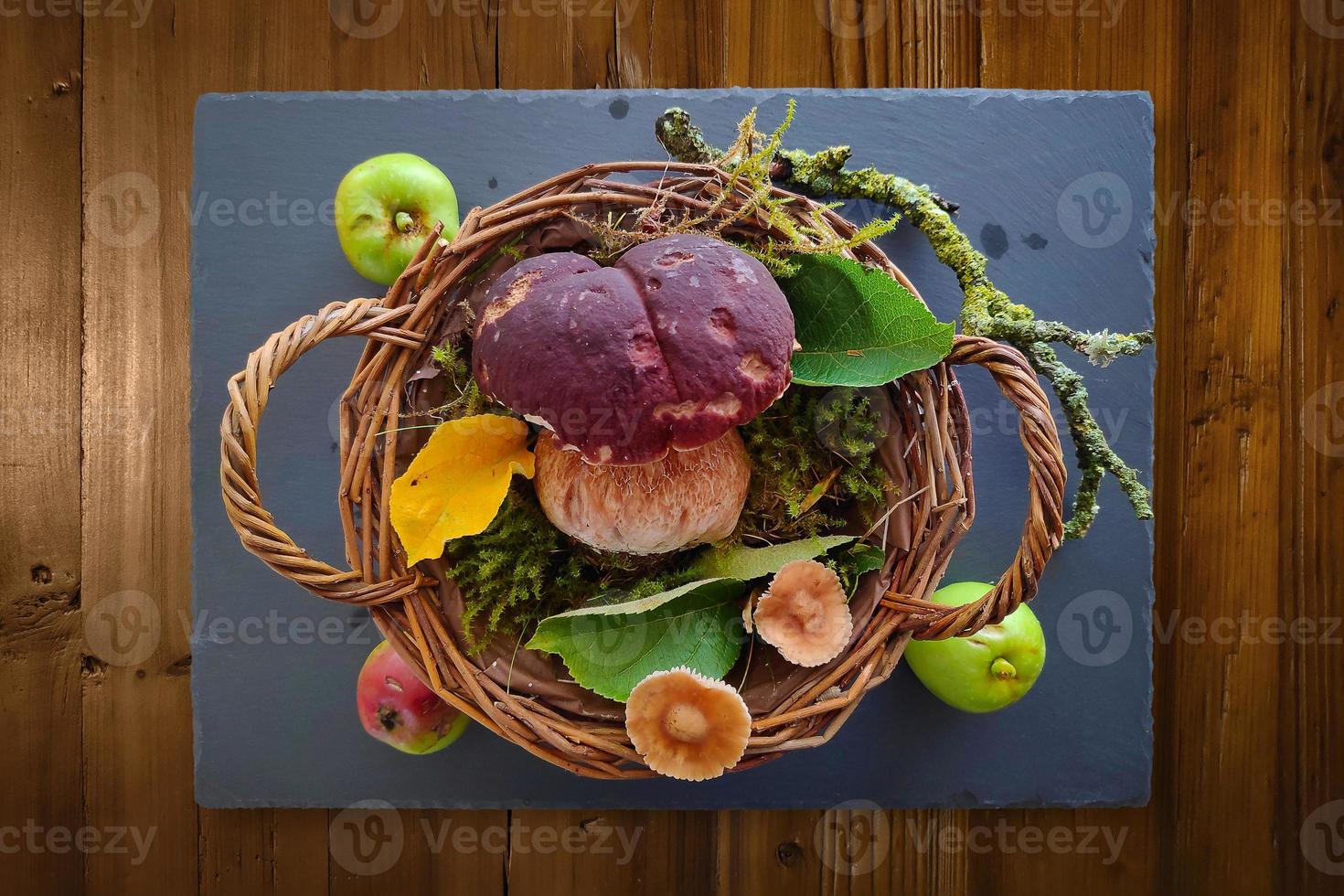 Steinpilze in einem Weidenkorb auf einer Schiefertafel foto