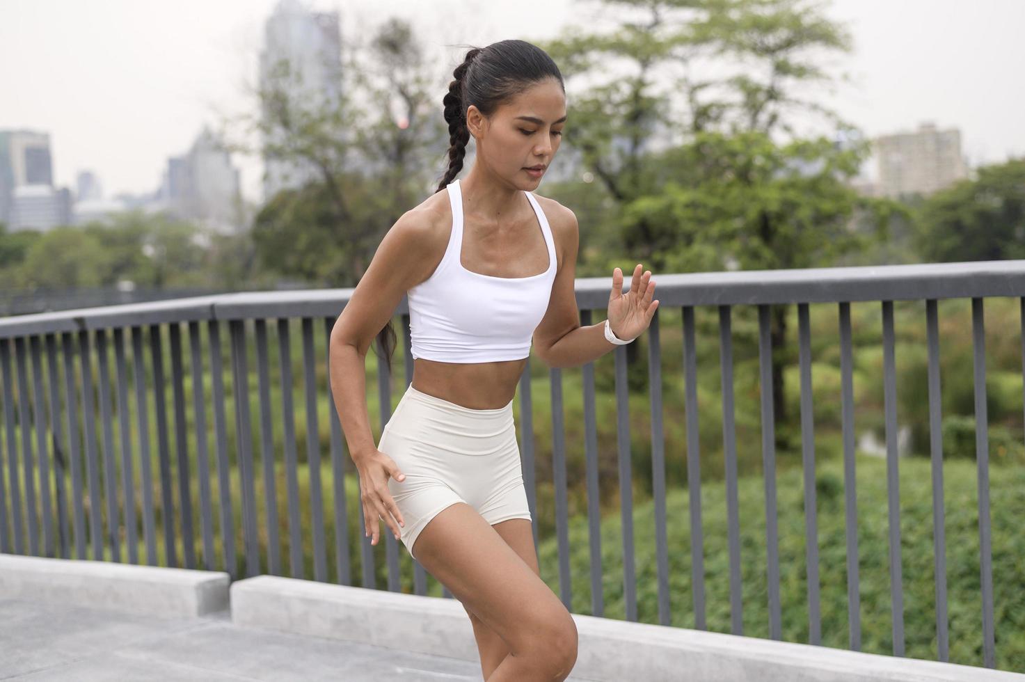 eine junge fitnessfrau in sportbekleidung, die im stadtpark trainiert, gesund und lebensstil. foto