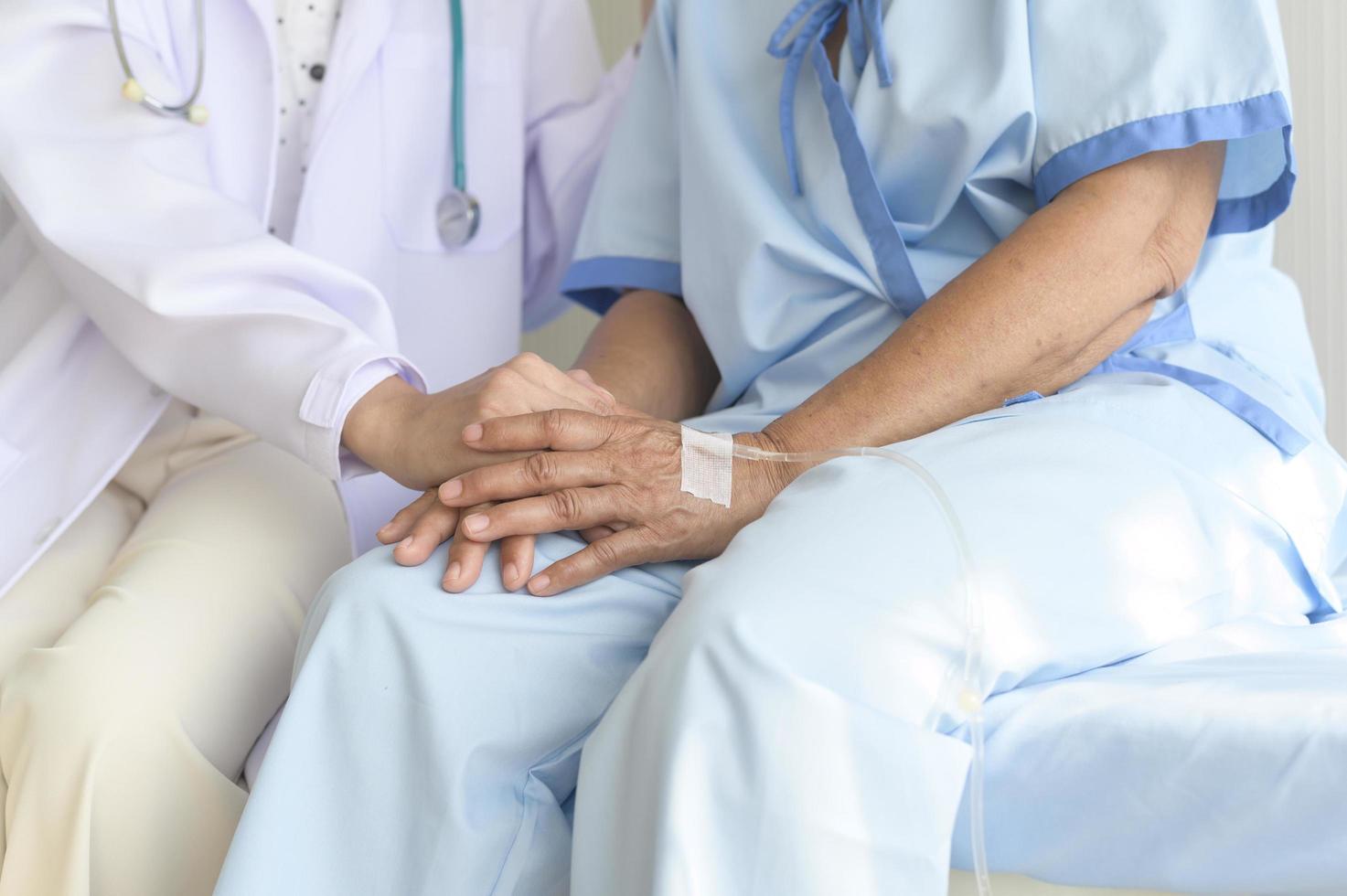 arzt, der die hand eines älteren krebspatienten im krankenhaus, im gesundheitswesen und im medizinischen konzept hält foto