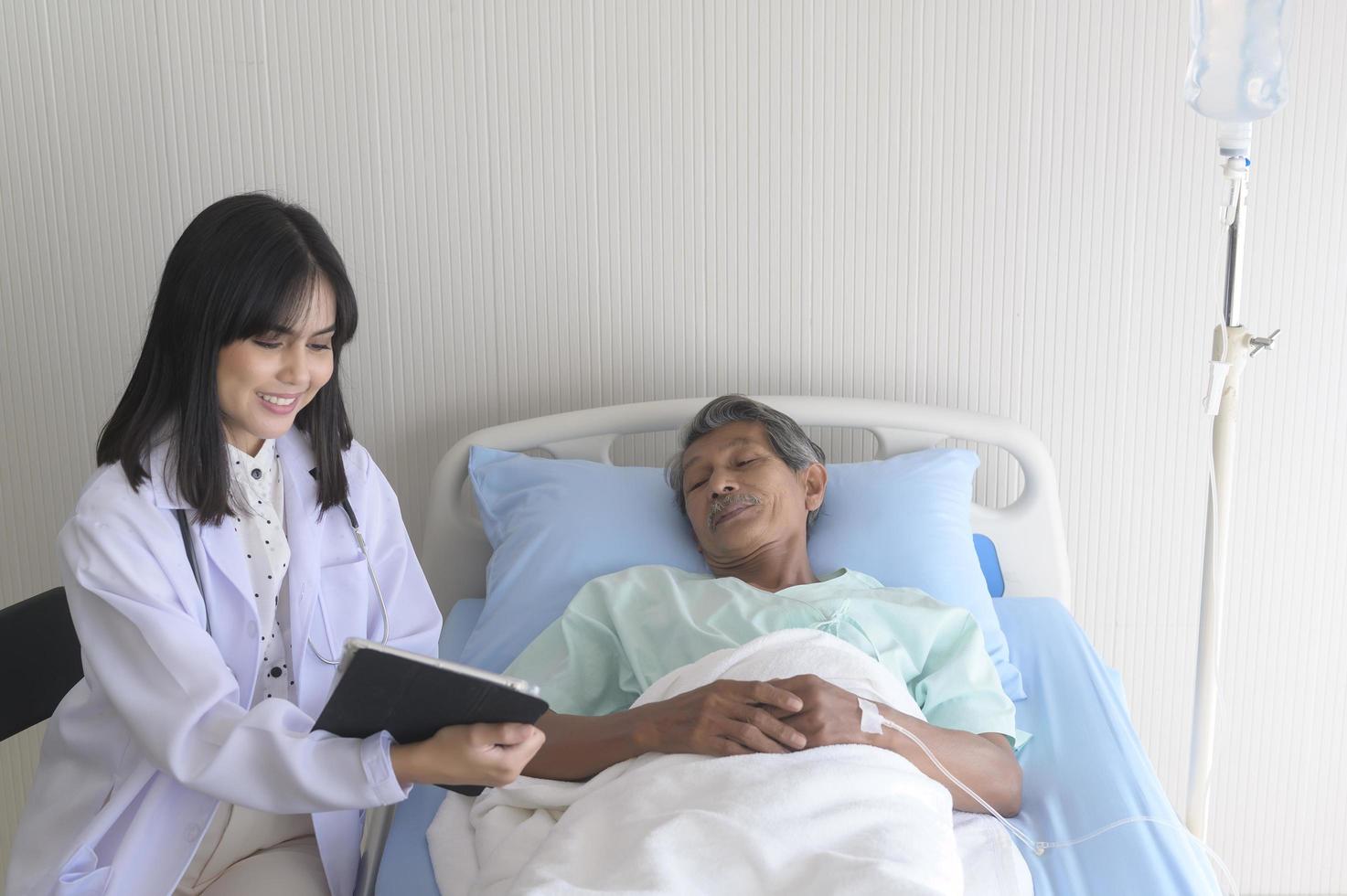 asiatischer älterer männlicher patient berät und besucht arzt im krankenhaus.. foto