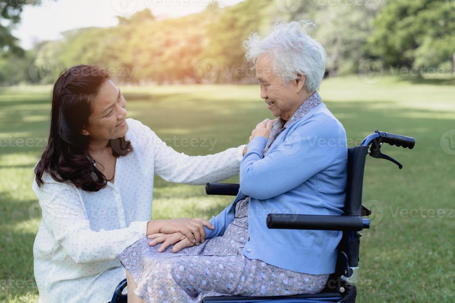 pflegekraft hilfe und pflege asiatische seniorin oder ältere alte dame patientin sitzt im rollstuhl im park, gesundes starkes medizinisches konzept. foto