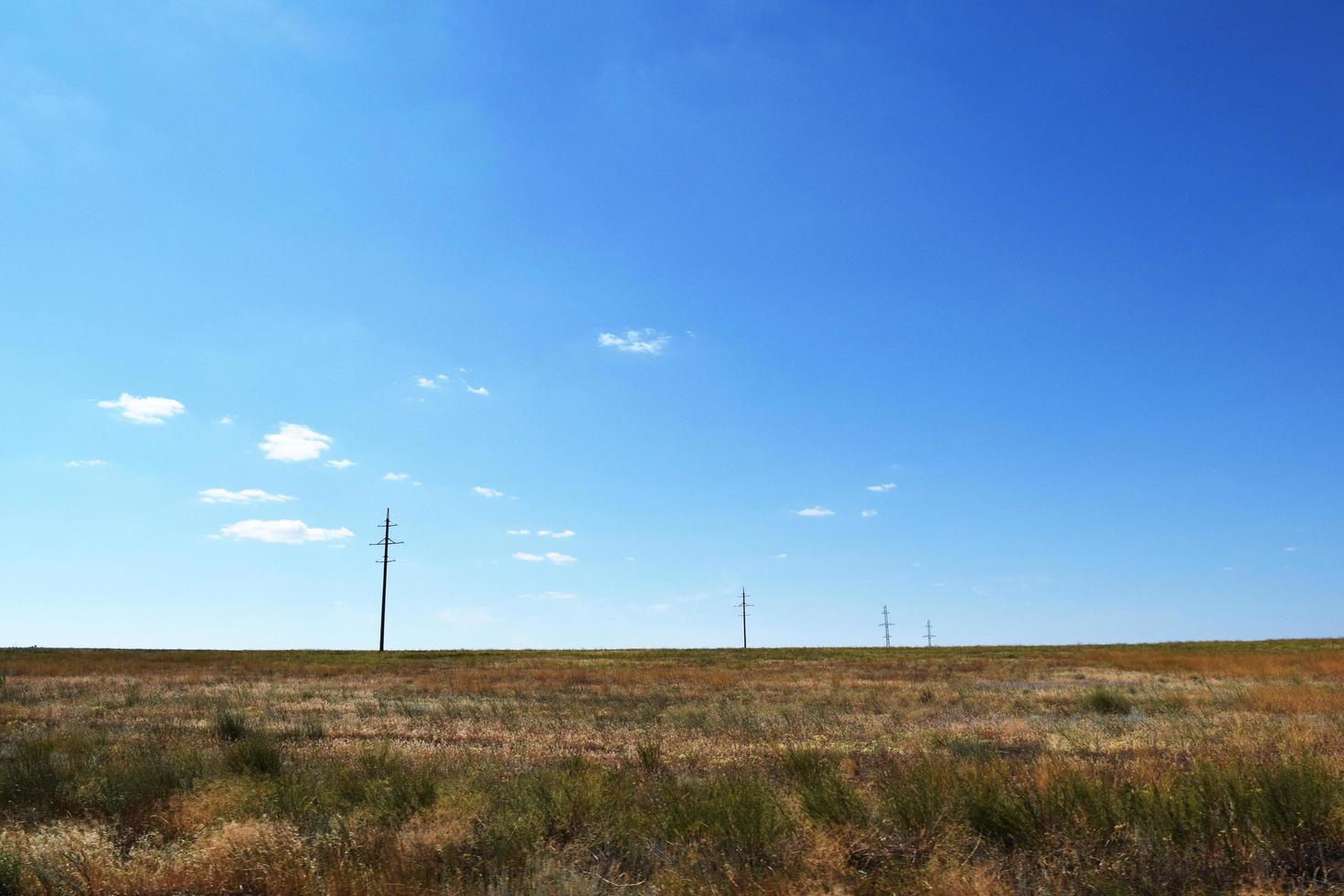 steppe an einem sonnigen heißen tag und stromleitungen foto