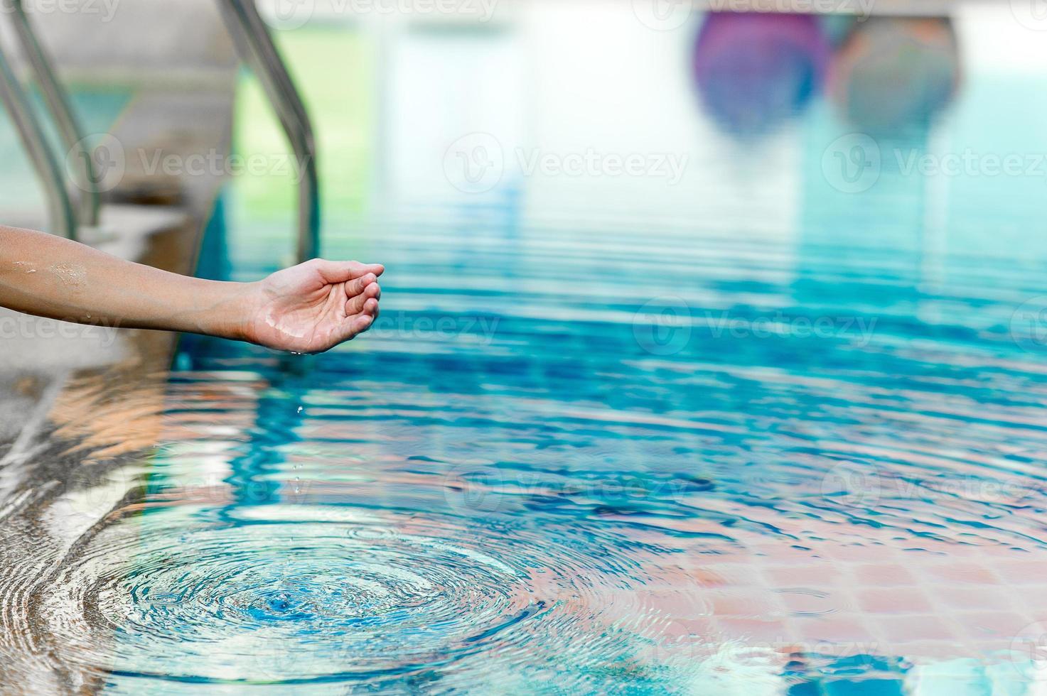 Hand und Wasser berühren das blaue Wasser. Um das Konzept des Spielens von sauberem Wasser mit Kopierraum aufzufrischen. foto