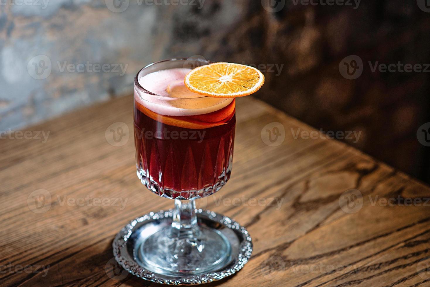 Roter Glühwein mit getrockneter Orange auf dem Tisch in der Bar foto