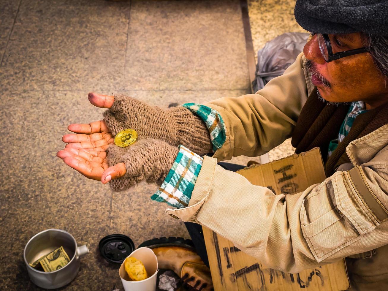 Ein armer Obdachloser ist schockiert, Spenden in Form von Bitcoin zu erhalten foto
