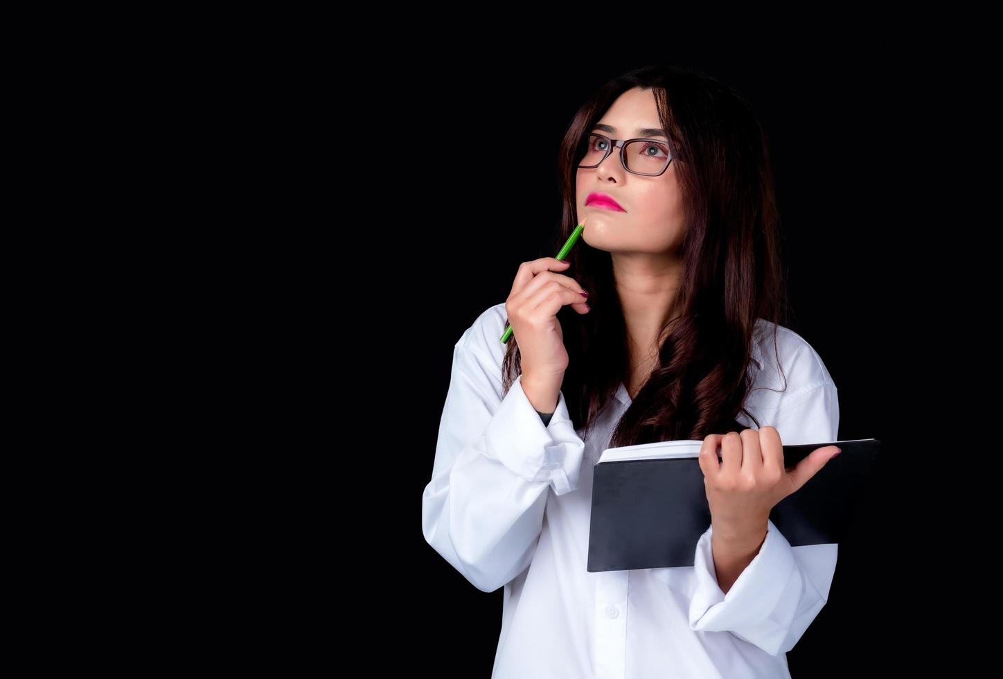 schöne und charmante Frauen in einfachen und entspannten Outfits, stehen und nutzen ihre Gedanken und notieren ihre Arbeit, während sie zu Hause arbeiten foto