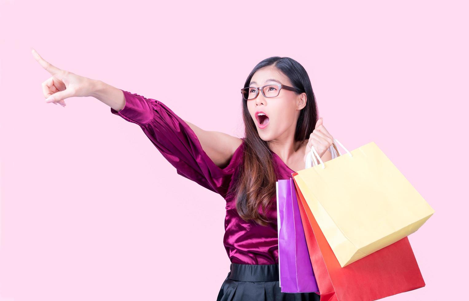 Eine schöne Asiatin ist glücklich und aufgeregt, wenn es ein Einkaufsmotiv gibt, die Produkte zu kaufen foto